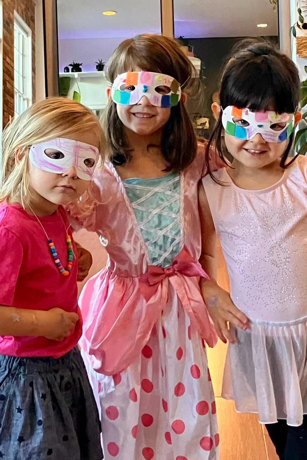 Two children in masks and party dresses