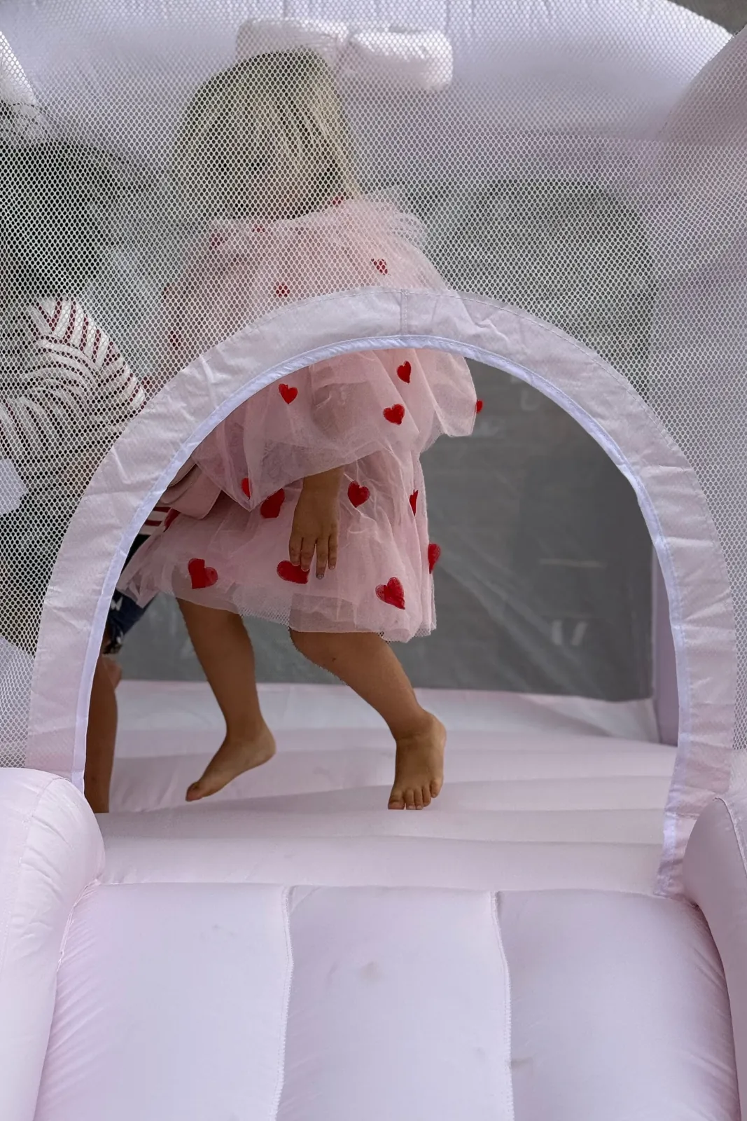 Toddler playing in a white bounce house