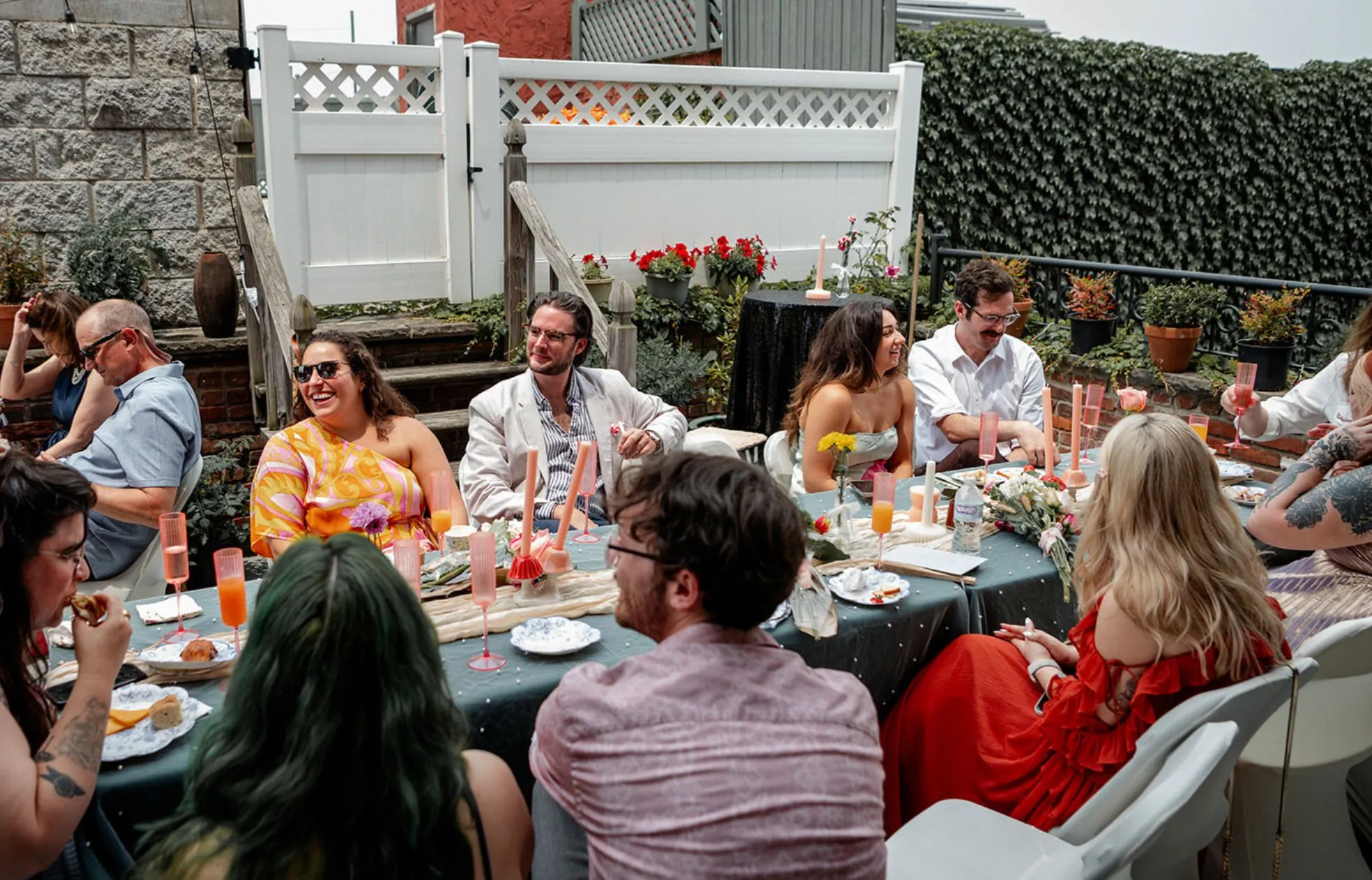 Guests sharing a meal at a long outdoor table