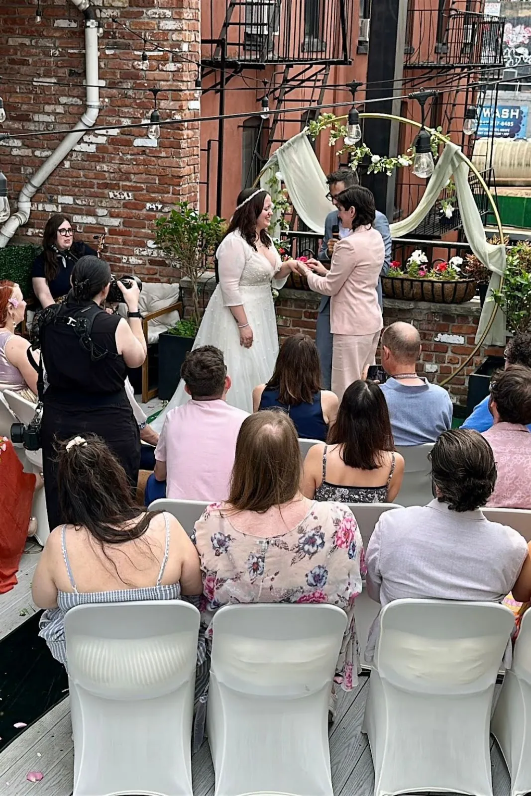 Wedding ceremony guests seated on chairs with white covers