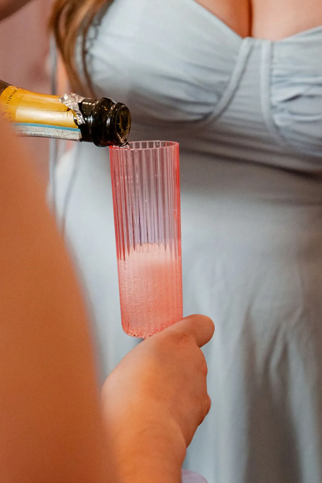 Pouring pink champagne into a flute