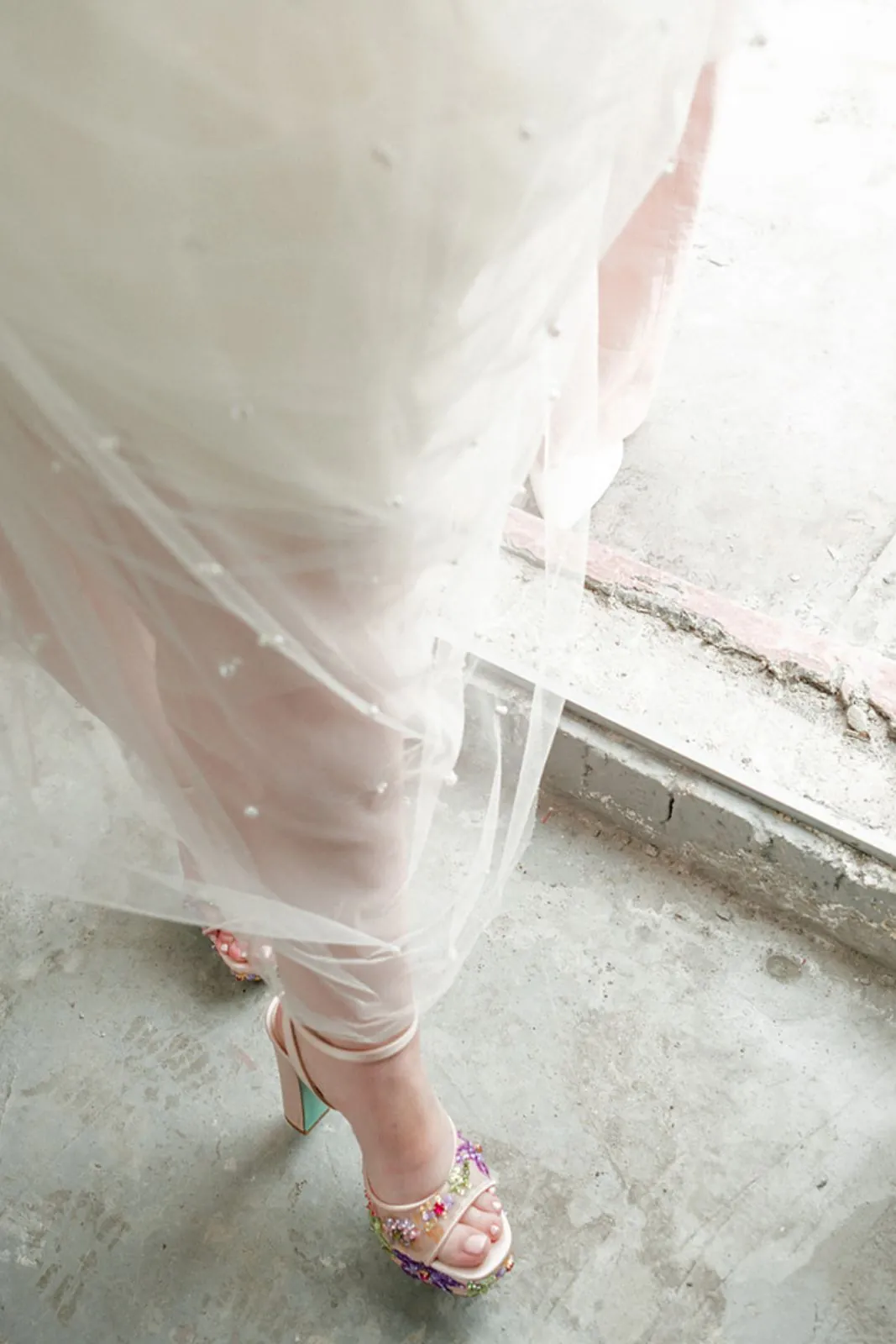 Bride's dress and heels by a sunny window