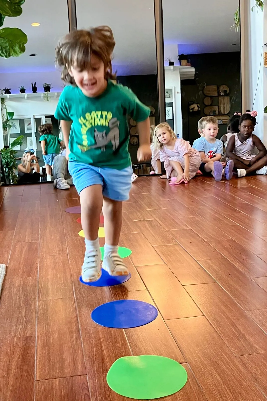 Child hopping on colored floor dots