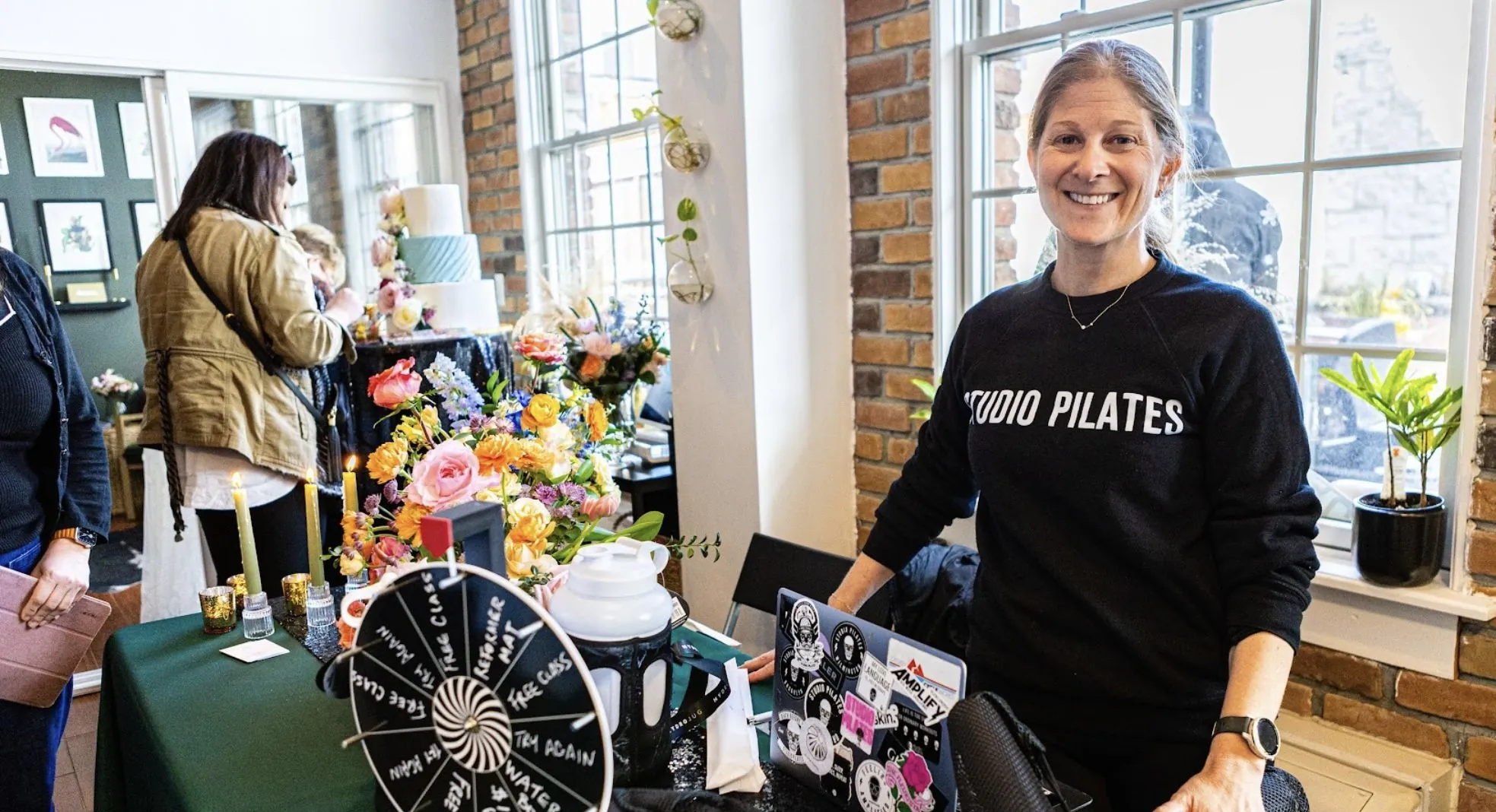 Vendor smiling at her display table during a pop-up market
