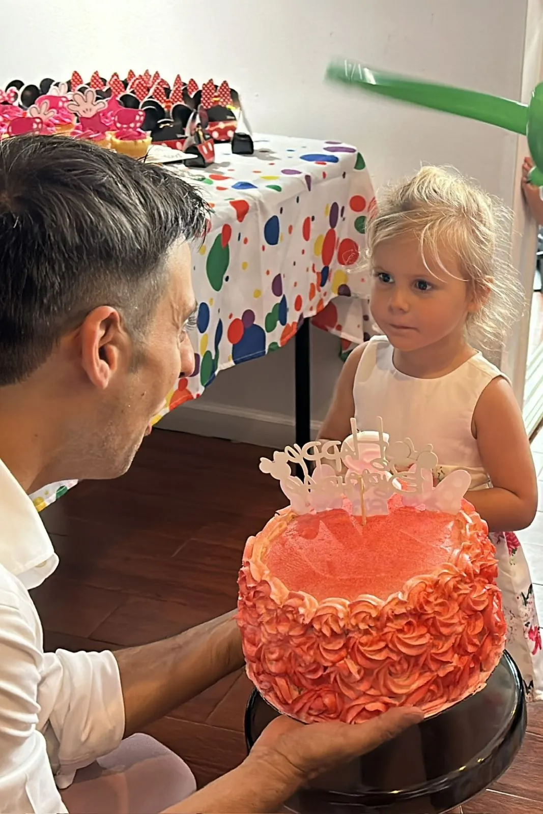 Father and child blowing out candles on a birthday cake