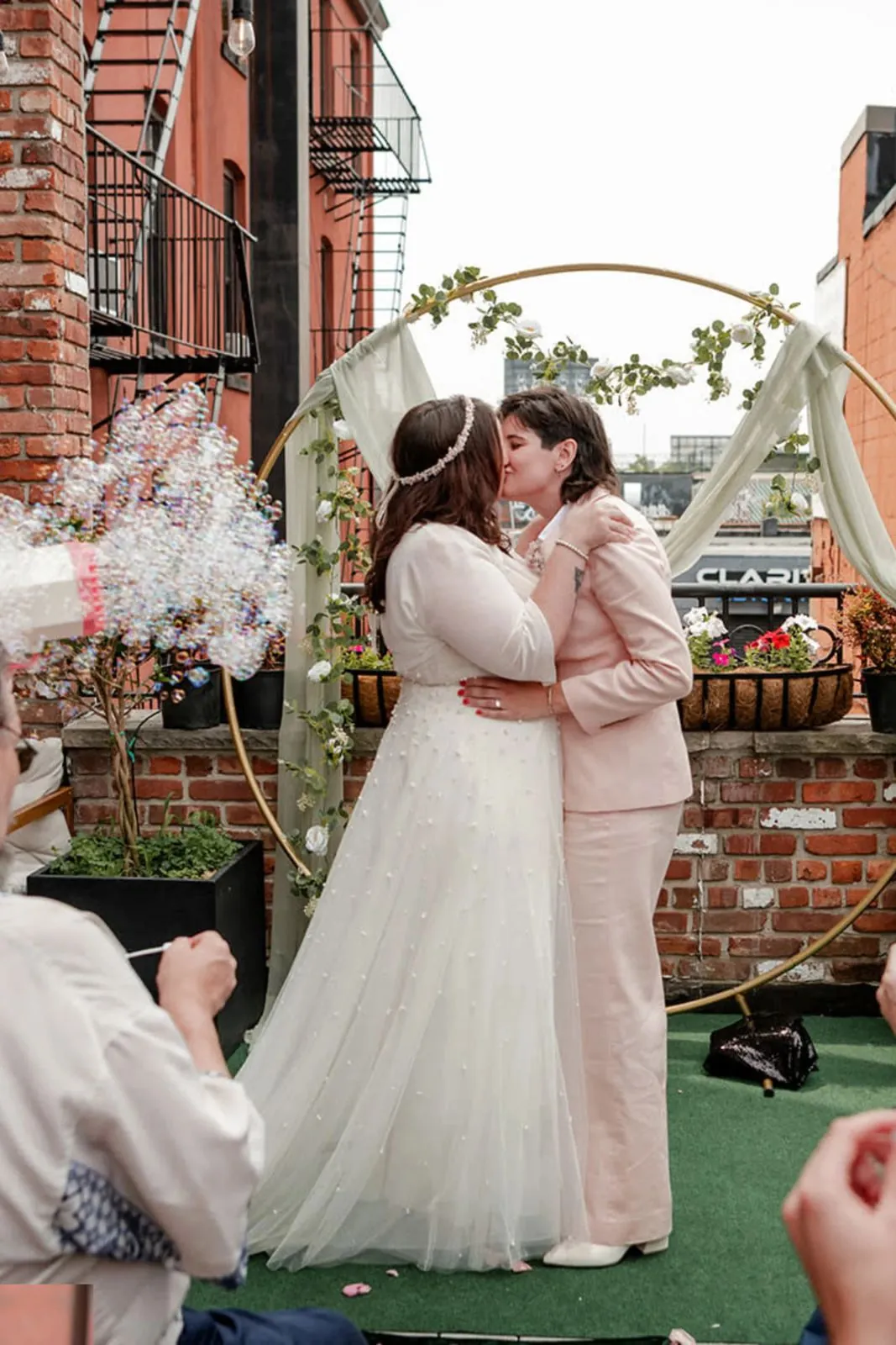 Newlyweds kissing under a floral arch on the terrace