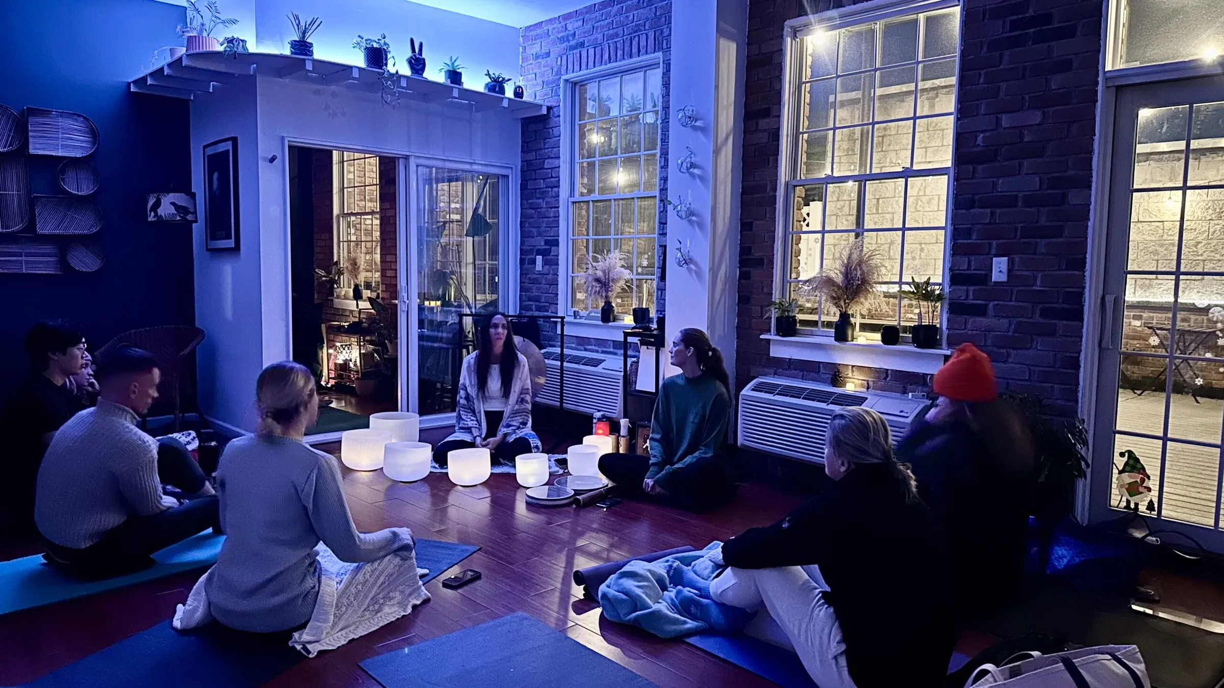 Candlelit sound bath with guests resting on the floor