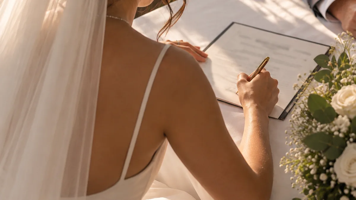 Bride signing her marriage license after the ceremony
